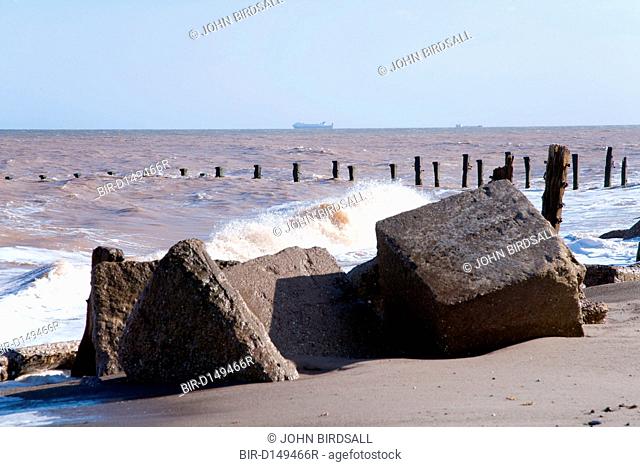 Waves crashing onto a groyne, concrete sea defences at Spurn Head, East Yorkshire, which is being eroded by the sea