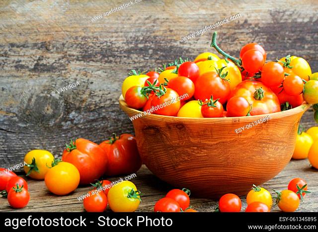 Wooden bowl with fresh vine ripened heirloom tomatoes from farmers market
