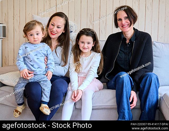 PRODUCTION - 03 March 2022, Berlin: Doula Denise Wilk (r) sits next to part of the Landes family: Maximilian 1 year old, mother Nina and Vicky, 8
