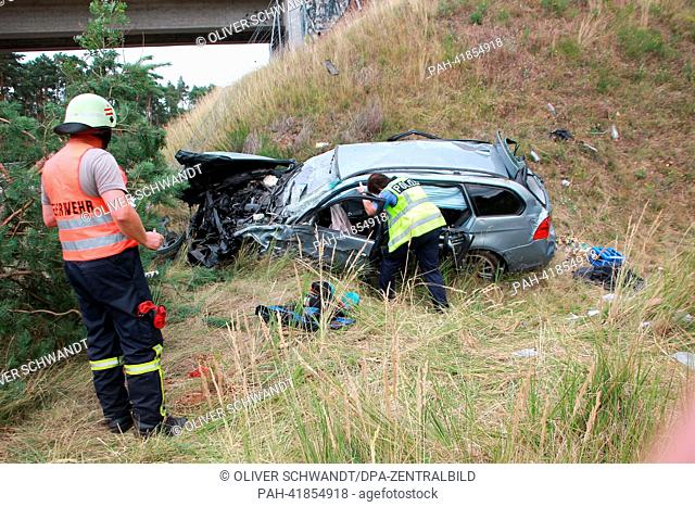A destroyed BMW lies at a bridge bank after a serious accident on autobahn A2 near Wolln, Germany, 18 August 2013. Five people were injured in the accident