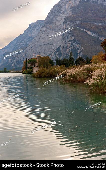 Lake Toblino with the castle in autumnal guise. It is a small Alpine lake in the province of Trento (Trentino-Alto Adige) and has been declared a Biotope for...