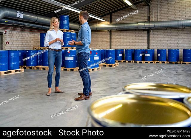 Male and female coworkers having discussion at paint warehouse