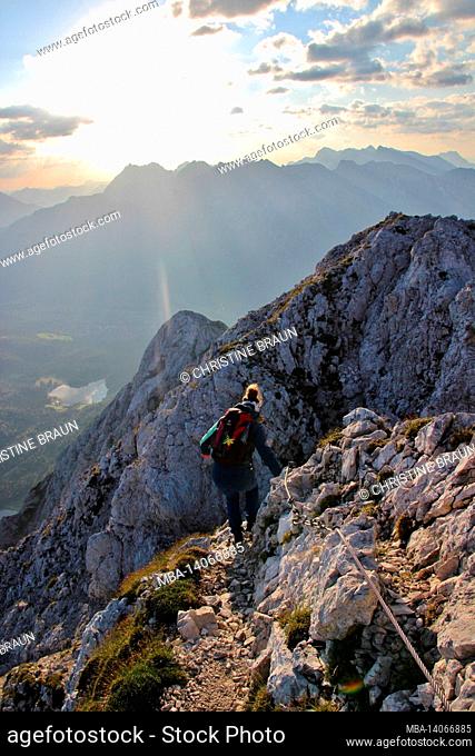 young woman descending, hike, obere wettersteinspitze, 2.297m in the background the lower wettersteinspitze, sunrise, karwendel mountains, germany, bavaria