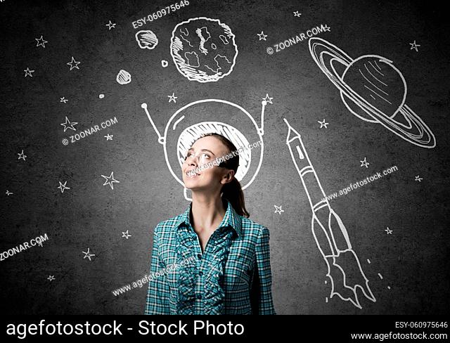 Student girl in jacket and glasses dreaming to become astronaut