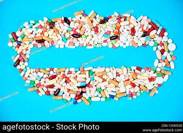 Textfreiraum in Rahmen aus Medikamenten und bunten Tabletten