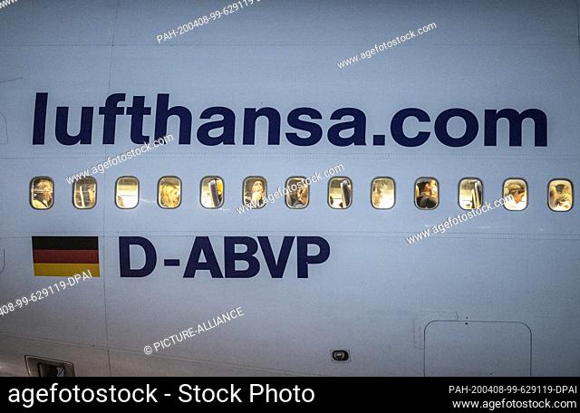 08 April 2020, Hessen, Frankfurt/Main: Passengers wait in the cabin of a Boeing 747 of Lufthansa after landing at Frankfurt Airport to be allowed to leave the...