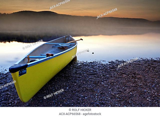 Canoe on the shore of Lac Monroe during sunset in Mont Tremblant National Park, Laurentides, Quebec, Canada
