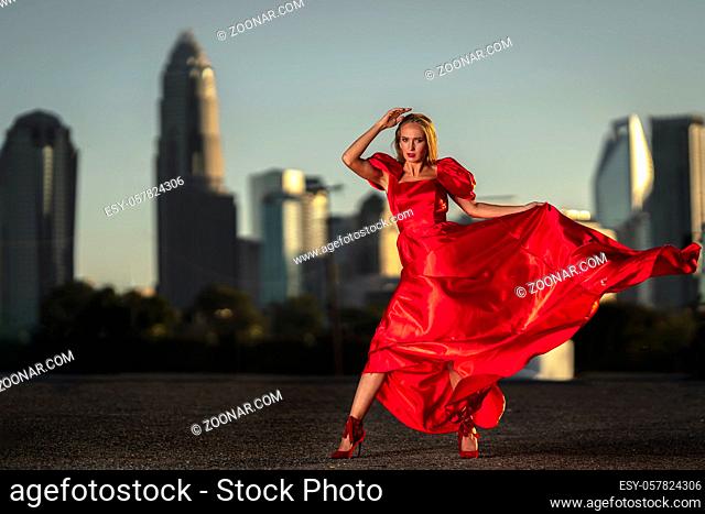 A gorgeous blonde model poses outdoors in her evening dress