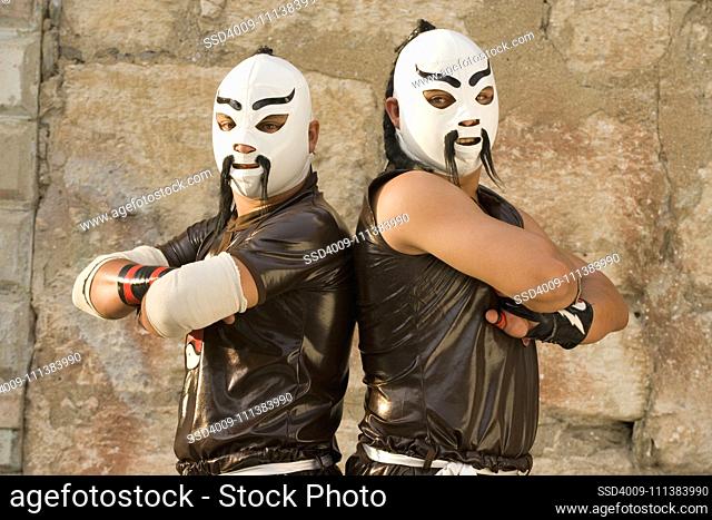 Hispanic men wearing Mexican wrestling costumes