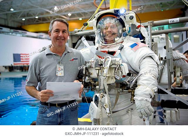 Astronaut Robert Behnken, attired in a training version of his Extravehicular Mobility Unit (EMU) spacesuit, and astronaut Stephen Robinson