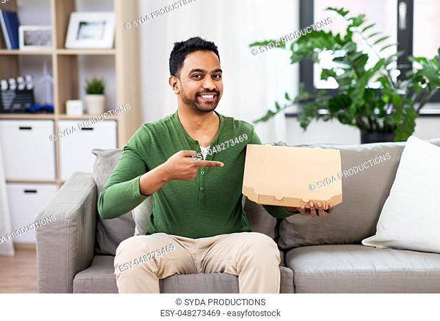 indian man with box of takeaway pizza at home