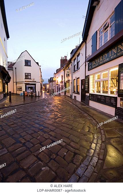 England, North Yorkshire, Whitby, Traditional cobbold street winding towards the Board Inn pub in Whitby