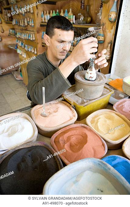 Creating colored sands bottles. The souks (arabic market area). City of Aqaba on the Red Sea. Kingdom of Jordan