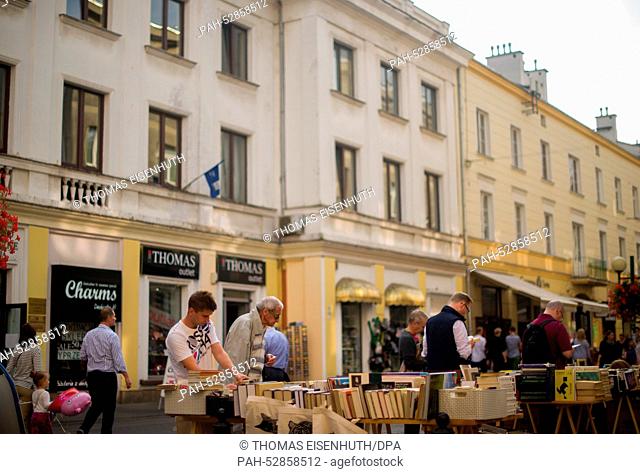 Residents and guests of the Polish capital walking through the inner city in the neighbourhood of New City (Nowe Miasto) and look for books at a fleamarket...