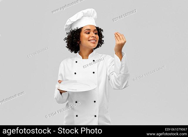 happy smiling female chef holding empty plate