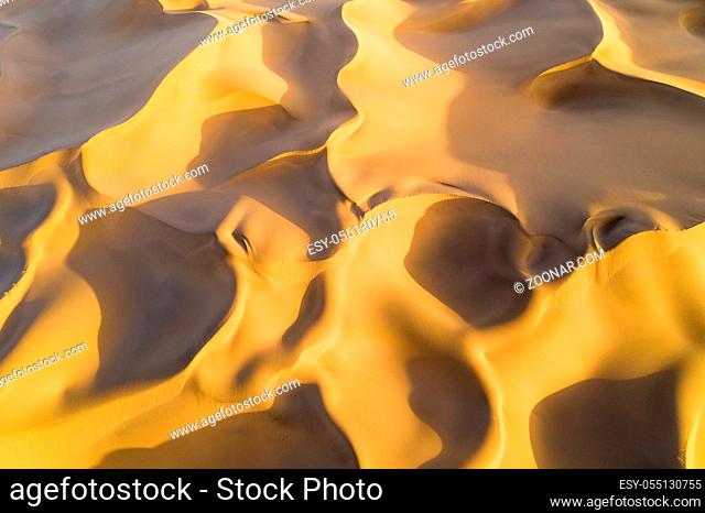 aerial view of desert landscape in sunset, golden sand dunes background texture