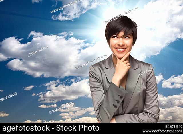 Pretty multiethnic young adult woman over blue sky and clouds with sun burst rays