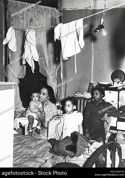 Negro family living in crowded quarters, Chicago, Illinois, April 1941. Creators: Farm Security Administration, Russell Lee