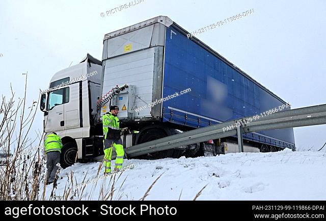 29 November 2023, Mecklenburg-Western Pomerania, Laage: A truck that has slipped away on a slippery road is parked on the A19 Rostock - Berlin highway in the...