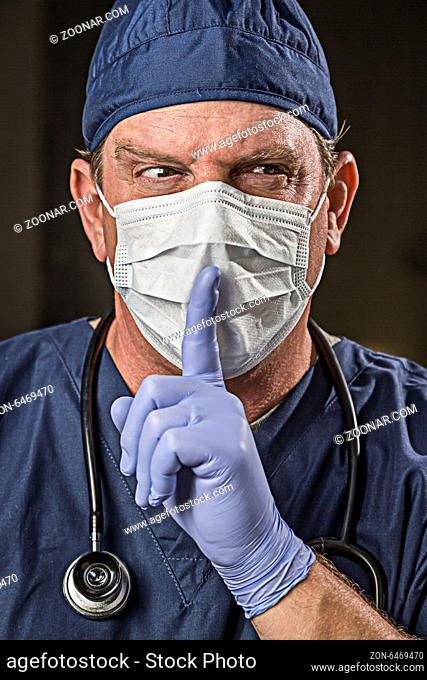Secretive Doctor or Nurse With Finger in Front of Mouth wearing Protective Wear and Stethoscope