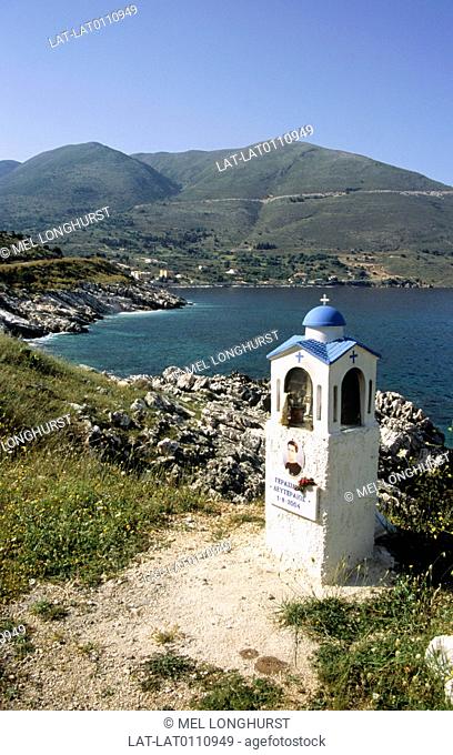 Ionian island, Cephallonia. Village. Coast. Small religious shirne. Image of young man. View to sea. Mountains