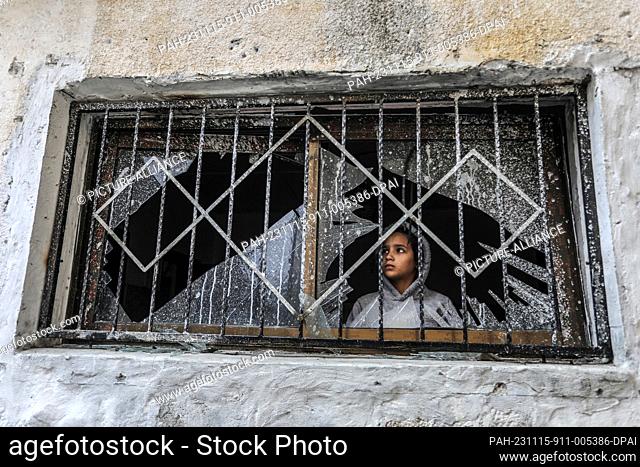 15 November 2023, Palestinian Territories, Rafah: A Palestinian child looks through a broken window of a destroyed house