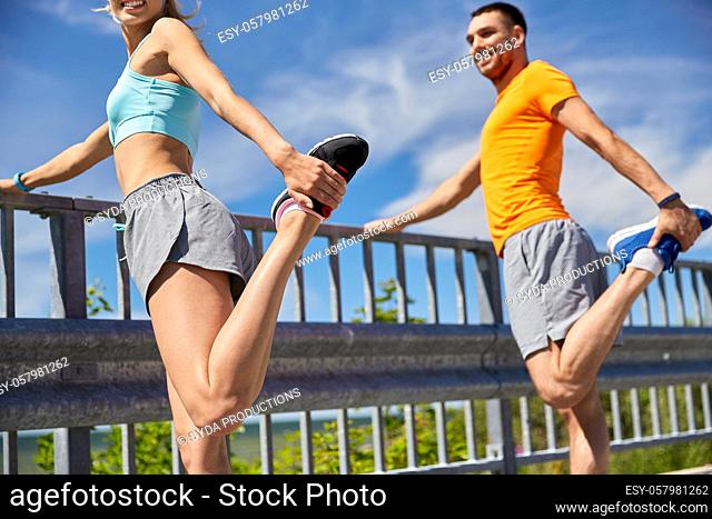 happy smiling young sporty couple stretching legs