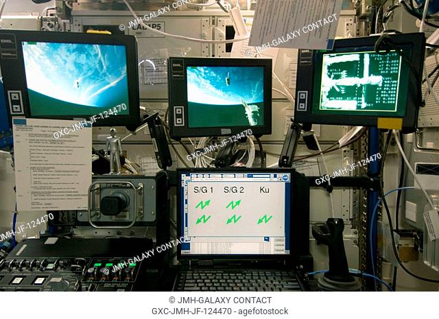 Three monitors in the Destiny laboratory of the International Space Station show views of the relocation of the Soyuz TMA-14 spacecraft from the Zvezda Service...