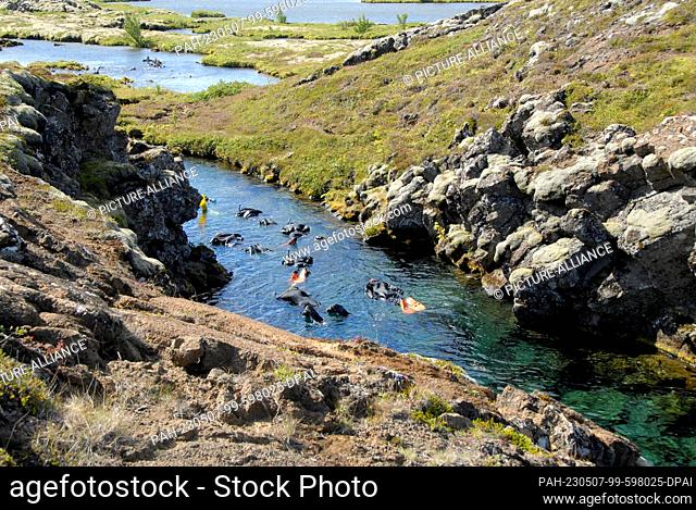 02 August 2022, Iceland, Thingvellir: Snorkelers explore the Silfra Fissure in Thingvellir National Park on the Golden Circle