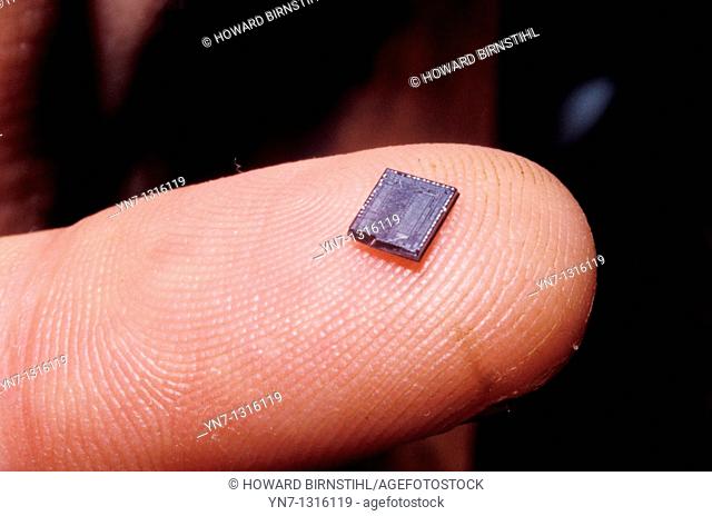 extreme close up of electronic chip on finger tip