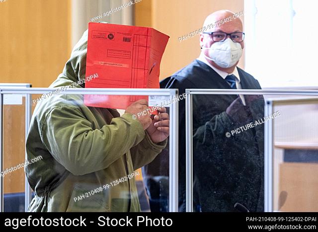08 April 2021, Bavaria, Regensburg: The defendant (l) stands next to his defense attorney Uwe Grabner in the hearing room at the Regional Court