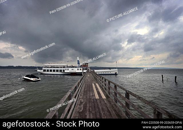 08 May 2022, Bavaria, Schondorf: The excursion steamer ""Diessen"" lies ready for departure at a jetty on the Ammersee under a cloudy sky