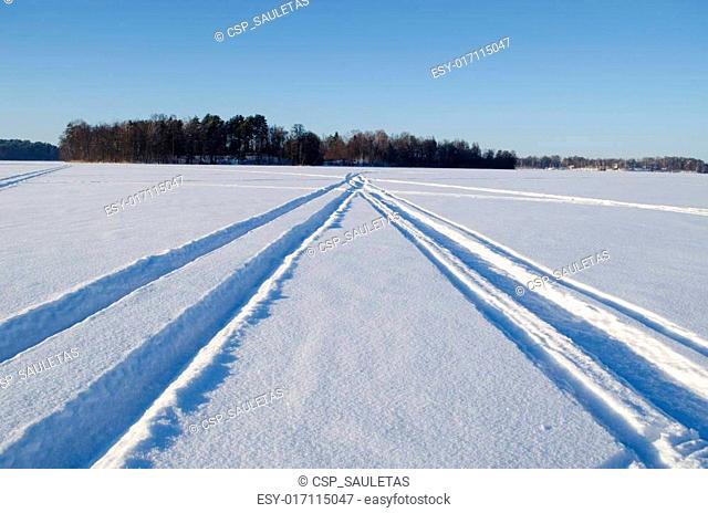 Snowmobile winter transport marks frozen lake snow