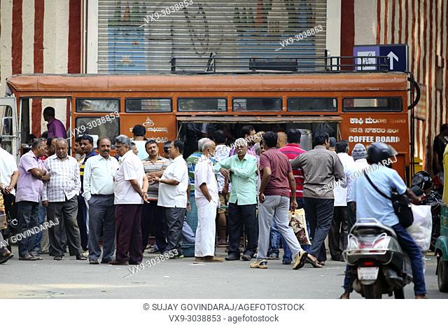 Bangalore, India - October 23, 2016: Large group of people buying hot coffee from a mobile canteen while other stand aside in the Avenue road