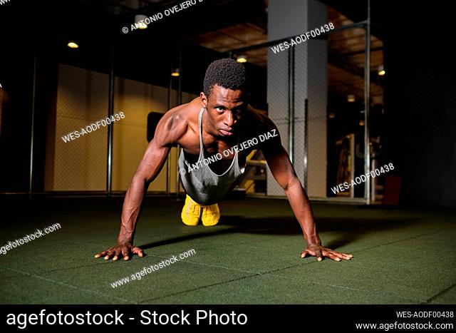 Athletic man doing push-ups exercise at gym
