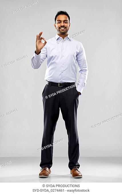 happy indian businessman in shirt over grey
