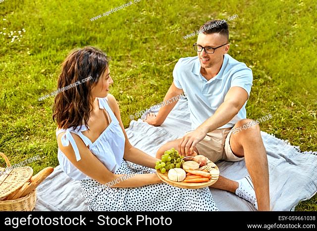 happy couple having picnic at summer park