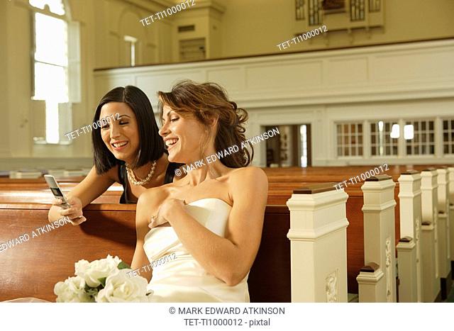 Bride and friend looking at cell phone