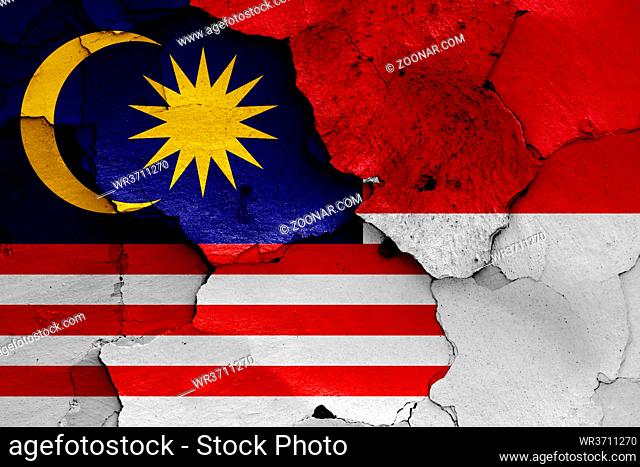flags of Malaysia and Indonesia painted on cracked wall