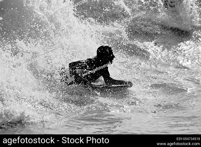 View of a silhouette of a boy surfin' the waves