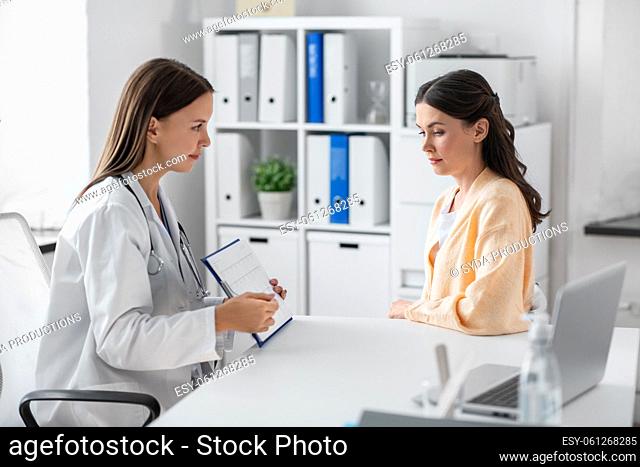 doctor showing cardiogram to woman at hospital