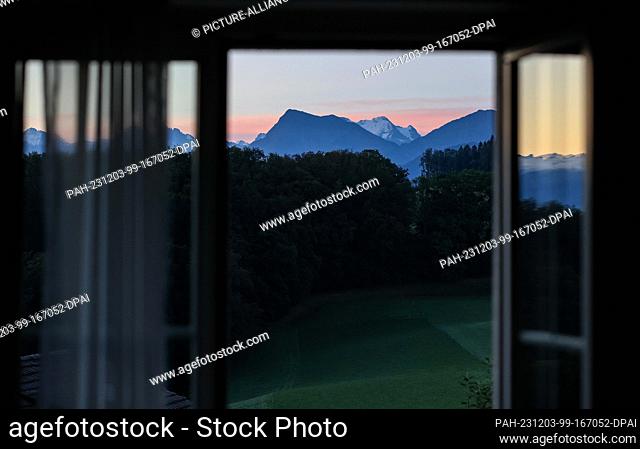 20 September 2023, Switzerland, Bern: A panorama of the Swiss mountains can be seen from a window at sunrise. Photo: Jan Woitas/dpa