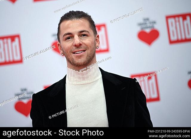 09 December 2023, Berlin: Riccardo Basile, presenter and dancer, stands on the red carpet of the TV fundraising gala ""A Heart for Children""