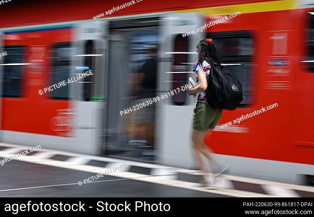 30 June 2022, Hessen, Frankfurt/Main: A woman walks to an S-Bahn train in the main station (shot with longer shutter speed)