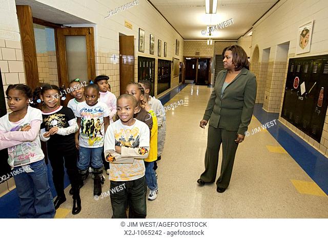 Detroit, Michigan - First grade teacher Ivy Bailey monitors girls in the hallway at MacDowell Elementary School