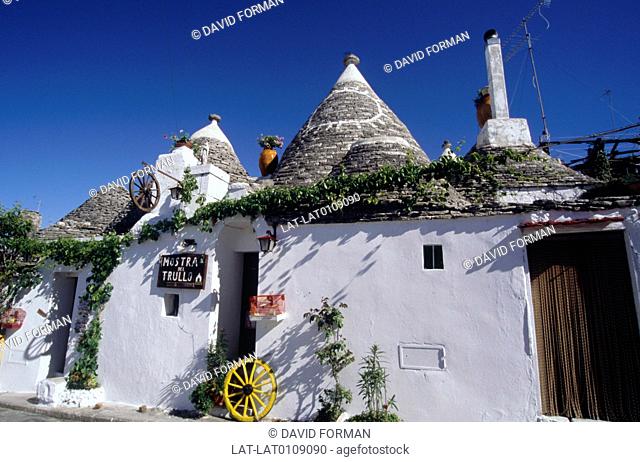 Trulli. Whitewashed buildings with conical thatched roofs. Inhabited, houses. Typical of region