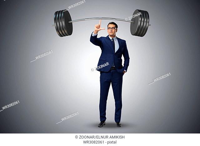 Businessman with barbell in heavy lifting concept