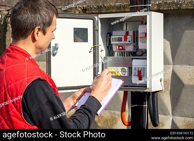 An energy sales worker takes readings of electricity meters