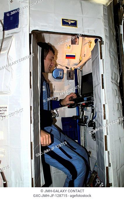 Cosmonaut Vladimir N. Dezhurov, Expedition Three flight engineer, works on a laptop computer in the Temporary Sleep Station (TSS) in the Destiny laboratory on...