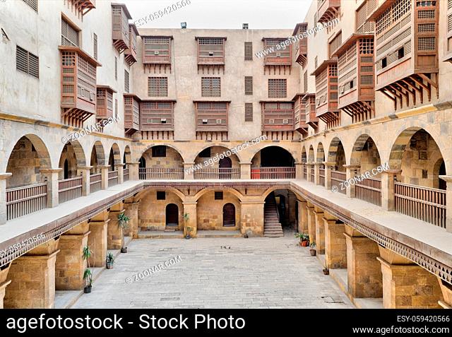 Facade of caravansary (Wikala) of Bazaraa, with vaulted arcades and windows covered by interleaved wooden grids (mashrabiyya), suited in Tombakshia street